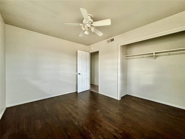 unfurnished bedroom with ceiling fan, a closet, and dark wood-type flooring