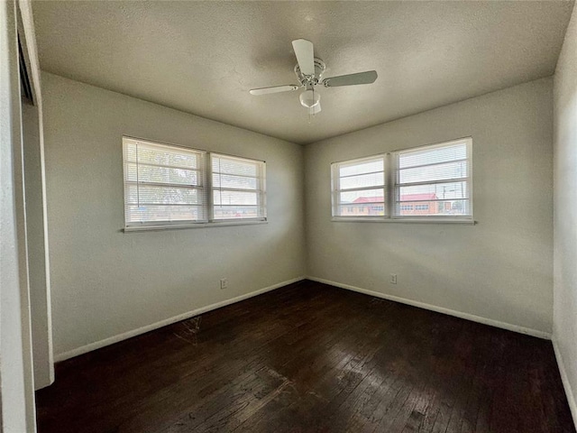 empty room featuring ceiling fan, dark hardwood / wood-style flooring, and a textured ceiling