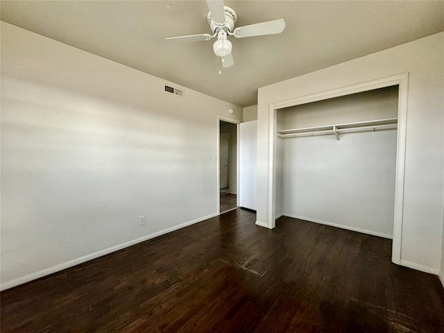 unfurnished bedroom featuring ceiling fan, dark hardwood / wood-style floors, and a closet