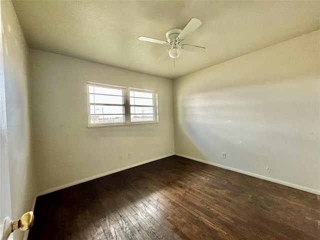 empty room with ceiling fan and dark wood-type flooring