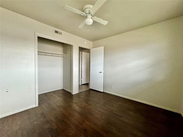 unfurnished bedroom with ceiling fan, dark wood-type flooring, and a closet