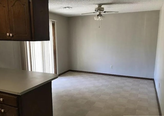 interior space with a textured ceiling and ceiling fan