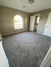 unfurnished bedroom featuring dark carpet