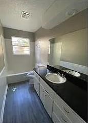 9816 NE 5th St, Midwest City, OK 73130 - bathroom featuring vanity and wood finished floors