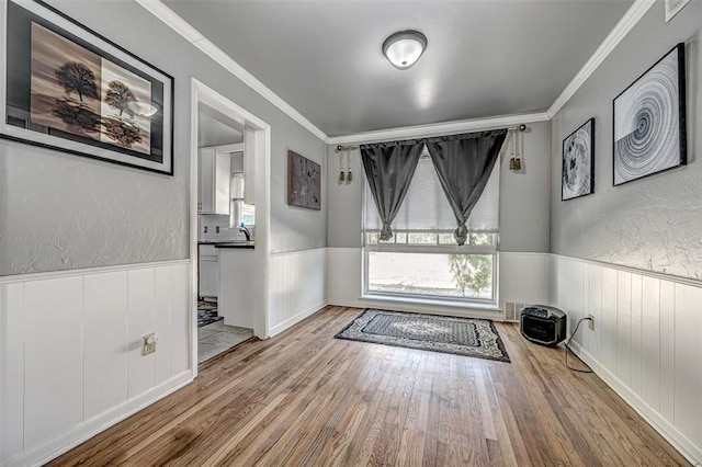 doorway to outside with crown molding and light hardwood / wood-style flooring