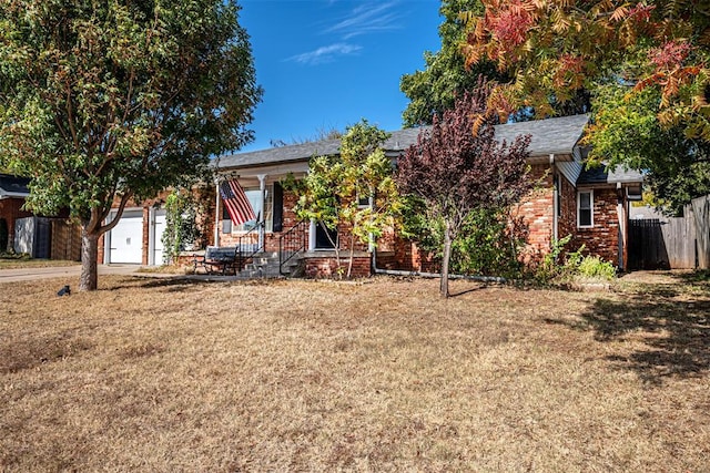 obstructed view of property featuring a garage and a front lawn