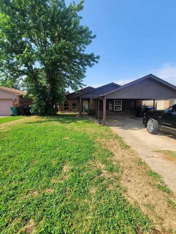 view of front facade featuring a front yard and a carport