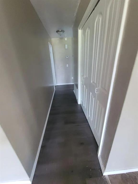 corridor with dark hardwood / wood-style flooring