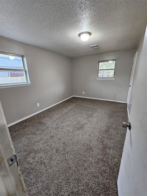 unfurnished room featuring carpet floors and a textured ceiling