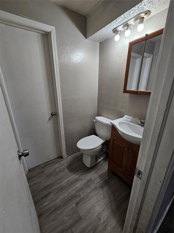 3200 Neighbors Ln, Del City, OK 73115 - bathroom with vanity, wood finished floors, a textured wall, and a textured ceiling