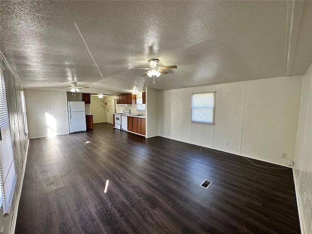 unfurnished living room with lofted ceiling, sink, ceiling fan, and dark hardwood / wood-style floors