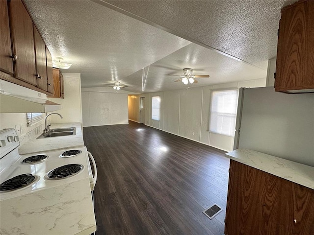 kitchen featuring a textured ceiling, sink, dark hardwood / wood-style floors, and white appliances