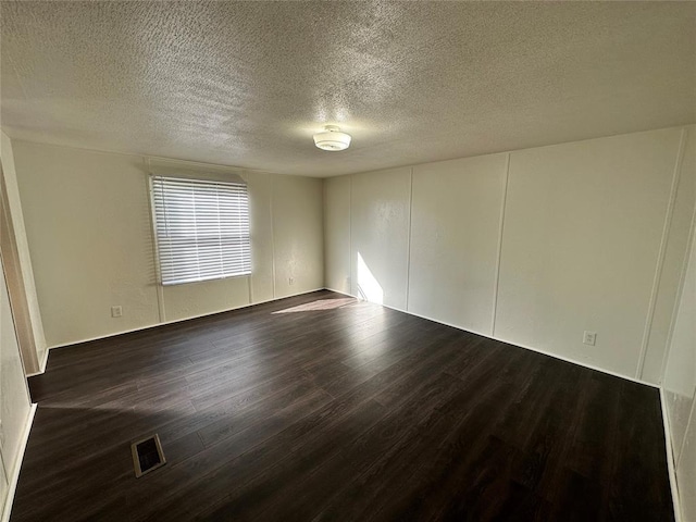 unfurnished room with a textured ceiling and dark wood-type flooring