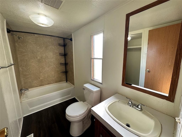 full bathroom featuring vanity, hardwood / wood-style flooring, toilet, a textured ceiling, and tub / shower combination