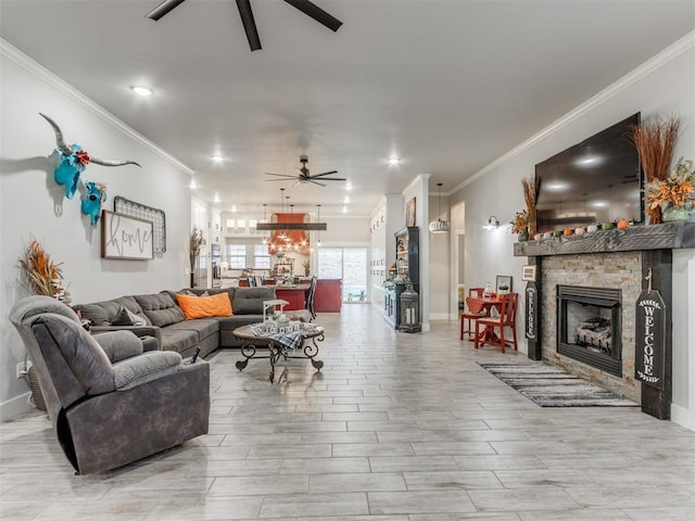 living room with ceiling fan, ornamental molding, and a fireplace