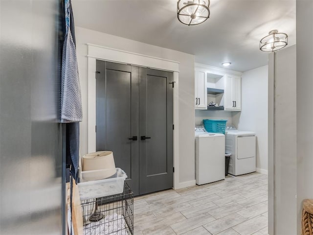 laundry area with washer and clothes dryer and cabinets