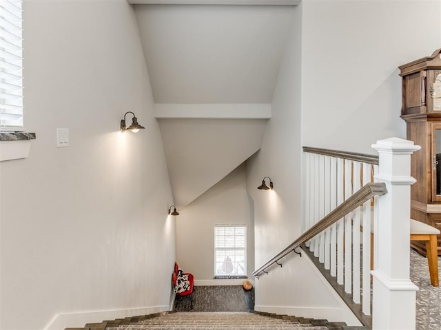 stairs with carpet flooring and lofted ceiling