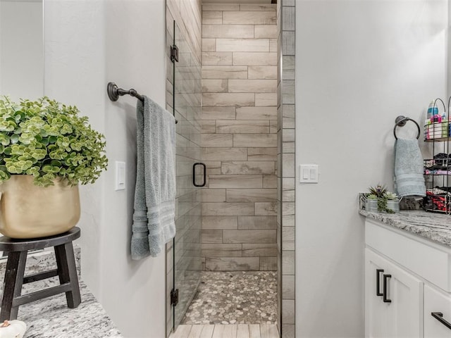 bathroom with vanity and a shower with shower door