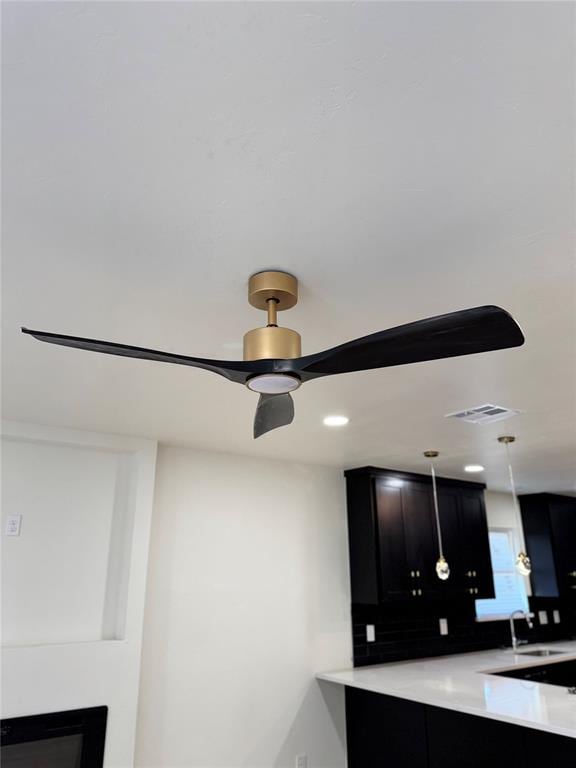 room details featuring backsplash, ceiling fan, and sink