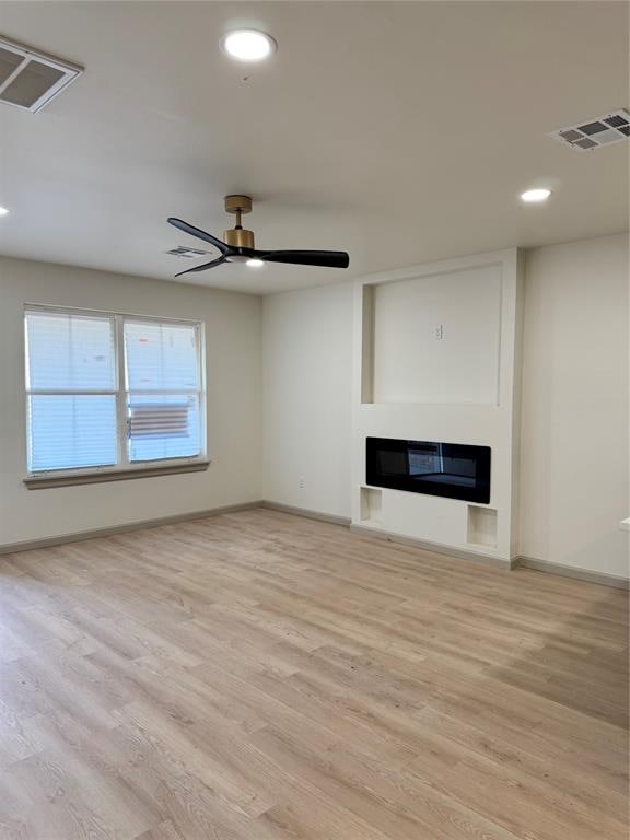 unfurnished living room with ceiling fan and light hardwood / wood-style floors