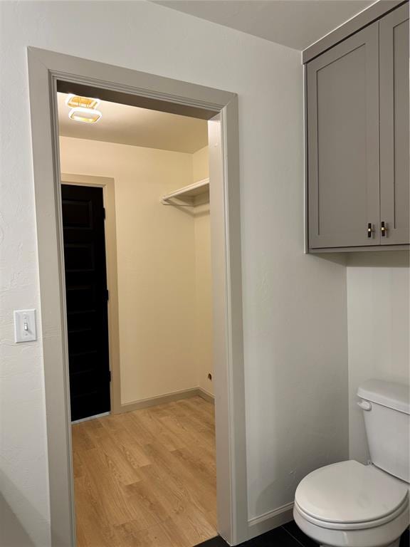 bathroom with toilet and hardwood / wood-style flooring