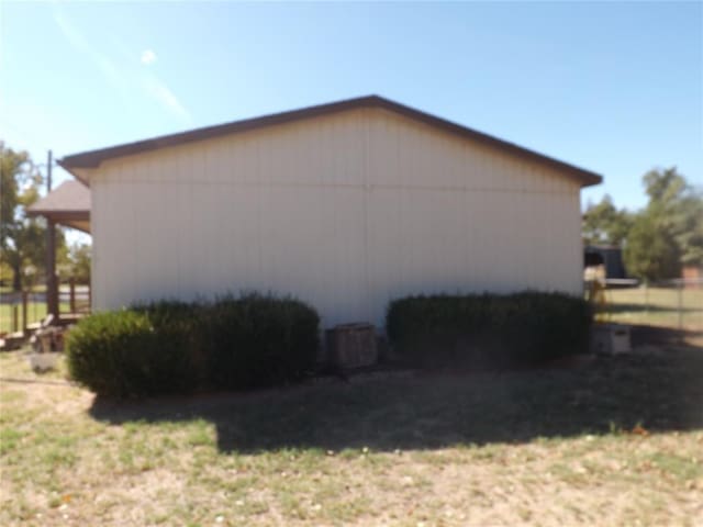 view of side of home with a yard and central AC unit