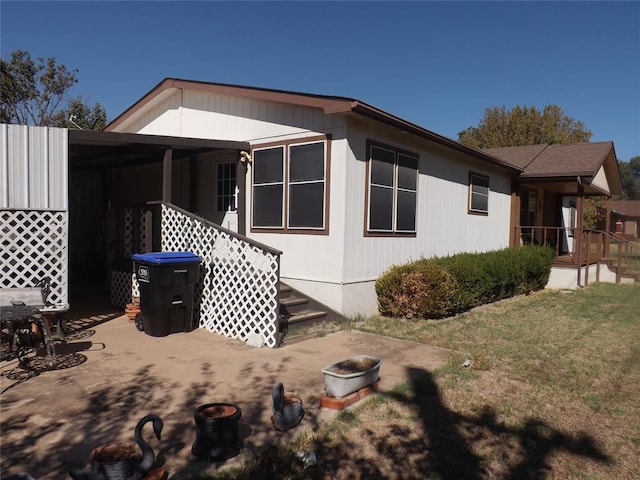 view of property exterior with a carport and a lawn