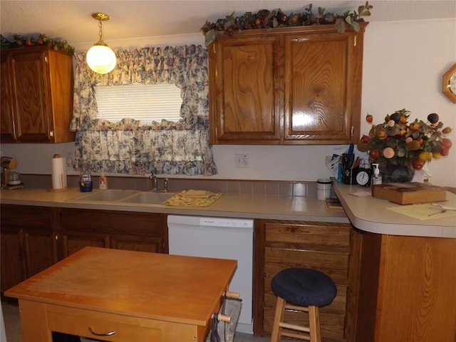 kitchen featuring white dishwasher, sink, and hanging light fixtures