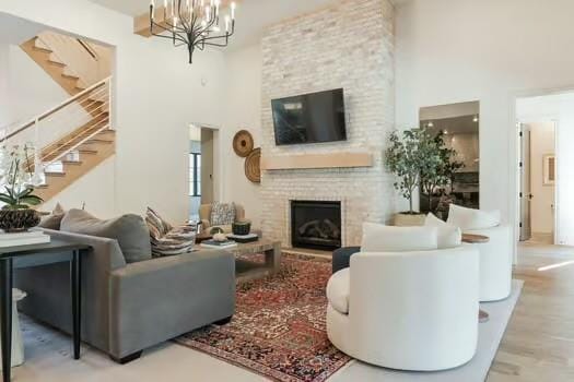 living room with a towering ceiling, a fireplace, and a notable chandelier