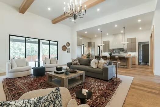 living room with an inviting chandelier, beam ceiling, and light hardwood / wood-style floors