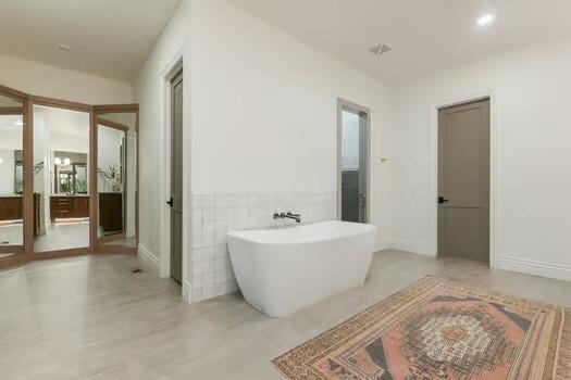 bathroom with a bath and tile walls