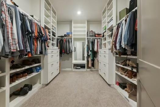 walk in closet featuring light carpet