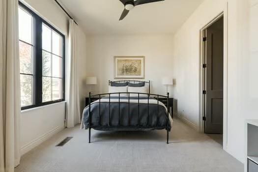 bedroom with ceiling fan and light carpet