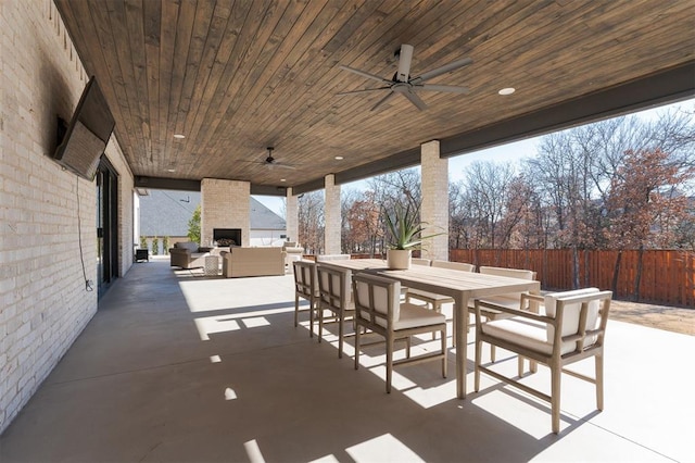 view of patio featuring an outdoor living space with a fireplace and ceiling fan