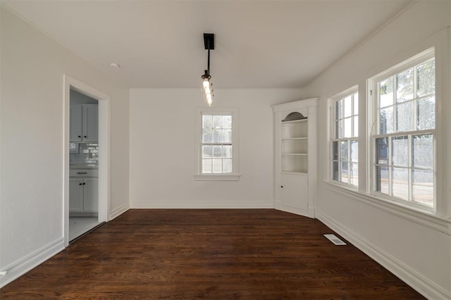 unfurnished dining area with plenty of natural light and dark wood-type flooring