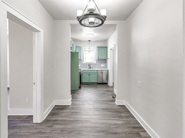 hall featuring dark hardwood / wood-style floors, sink, and a chandelier