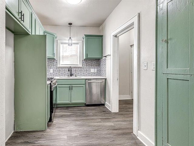 kitchen featuring sink, tasteful backsplash, wood-type flooring, pendant lighting, and appliances with stainless steel finishes