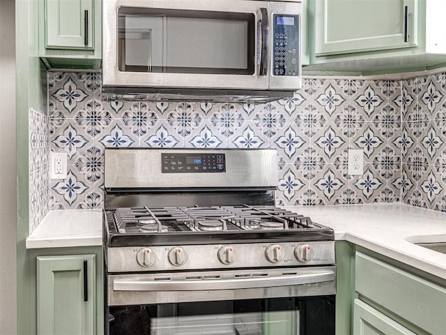 kitchen with stainless steel appliances and green cabinetry