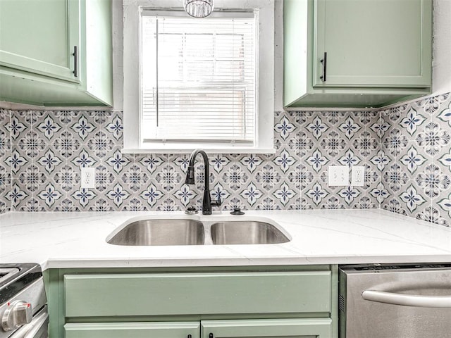 kitchen with light stone countertops, sink, appliances with stainless steel finishes, and green cabinetry