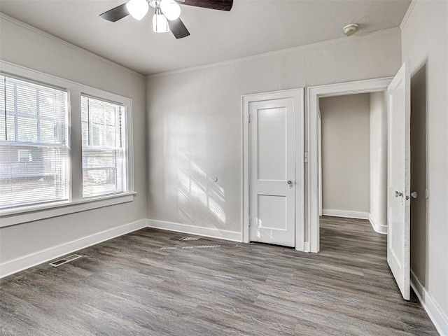 unfurnished bedroom with ceiling fan, dark hardwood / wood-style floors, and ornamental molding