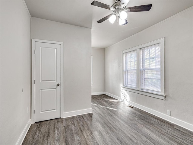 unfurnished room featuring crown molding, ceiling fan, and dark wood-type flooring