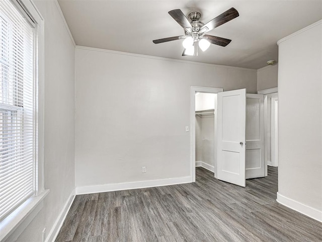 unfurnished bedroom with a closet, ceiling fan, hardwood / wood-style floors, and crown molding