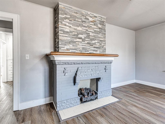 details with a fireplace, ornamental molding, a textured ceiling, and hardwood / wood-style flooring