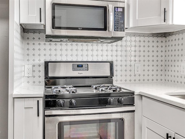 kitchen featuring decorative backsplash, white cabinetry, and stainless steel appliances