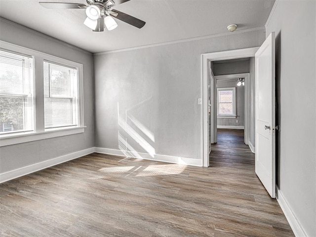 unfurnished room featuring ceiling fan, dark hardwood / wood-style flooring, and ornamental molding