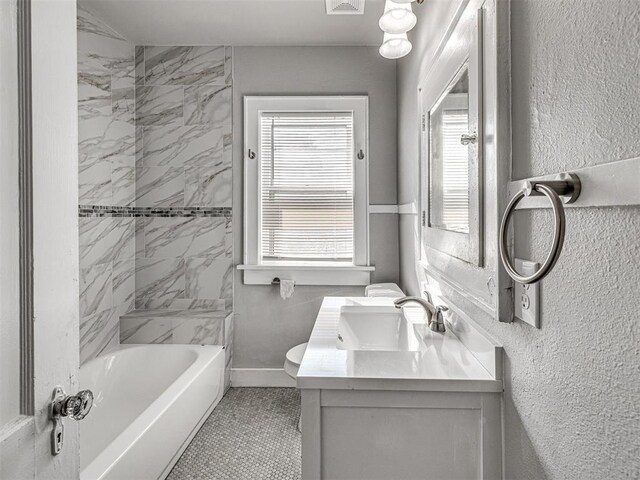 full bathroom with tile patterned flooring, vanity, toilet, and tiled shower / bath