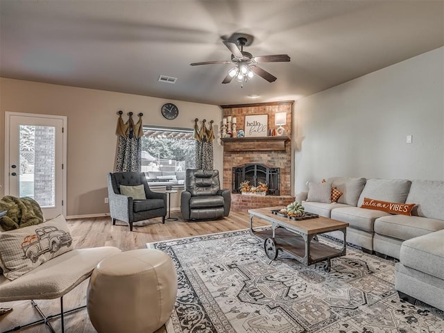 living room with ceiling fan, a fireplace, and hardwood / wood-style flooring