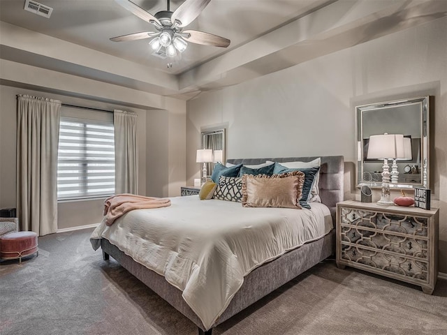 bedroom with ceiling fan, a raised ceiling, and carpet floors