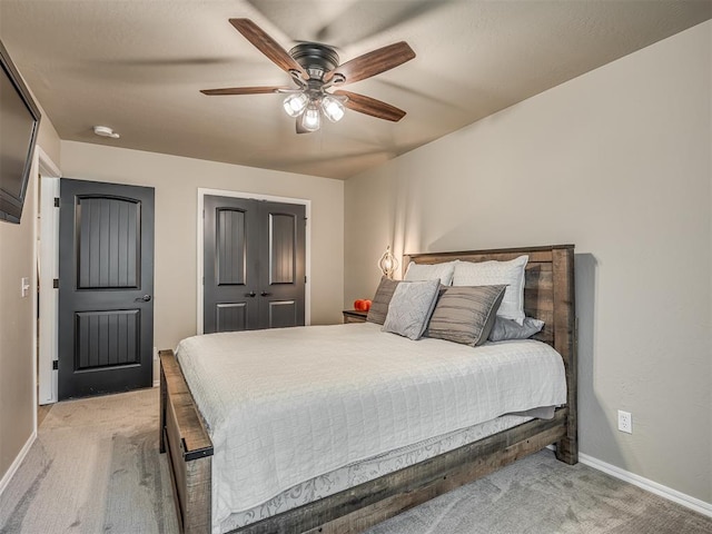 carpeted bedroom with ceiling fan and a closet