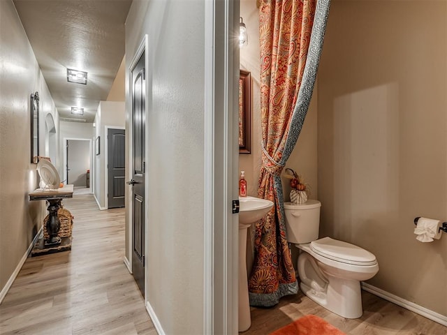 bathroom featuring hardwood / wood-style floors and toilet